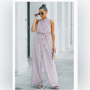 Pink and white polka dot, sleeveless, pant romper with partial open back & belt